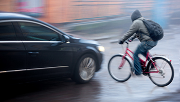 A person rides a bicycle under rain